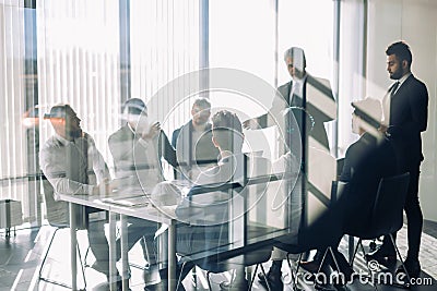 Side view of blurred silhouettes of businessmen talking in conference room Stock Photo