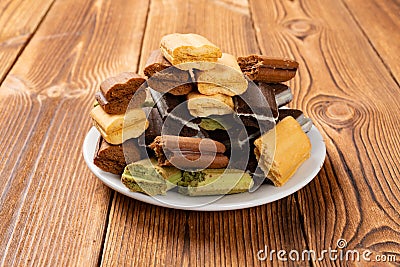 Broken multicolor sandwich cookies on a wood table Stock Photo