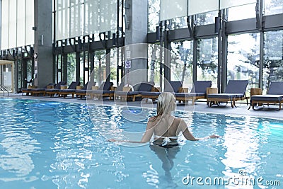 Side view of a Caucasian woman resting at poolside. She is enjoying a quiet weekend at the spa Stock Photo