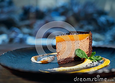 Side view of chocolate piece of cheesecake with mango Stock Photo