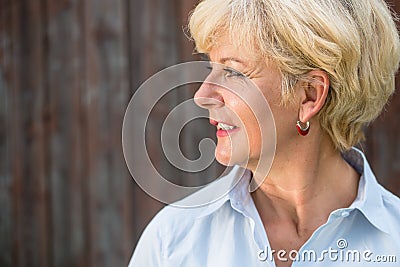 Nostalgic senior woman looking away with a smile while daydreami Stock Photo