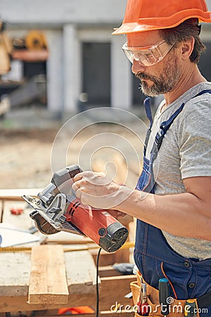 Focused carpenter getting ready for cutting wood Stock Photo