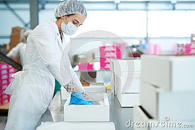 Confectioner at factory putting parchment into box Stock Photo