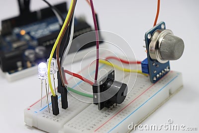 Side view of Different electronic components on a breadboard circuit with microcontroller on the background showing the concept of Stock Photo