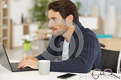 side view disabled businessman using laptop in home office Stock Photo