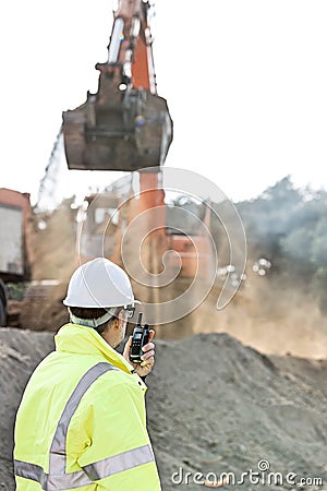 Side view of engineer using walkie-talkie at construction site Stock Photo