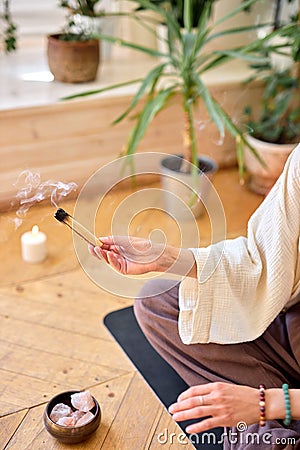 Side view on female use palo santo for meditation and aroma therapy at home Stock Photo
