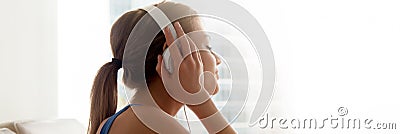 Side view female wearing headphones enjoy favorite music at home Stock Photo