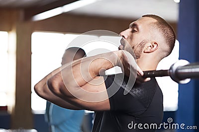 Side View - Fit Young Lifting Barbells in Gym. Stock Photo