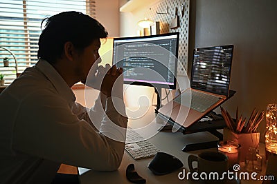 Side view of focused software developer programming on desktop computer Stock Photo