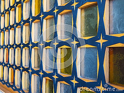 Side view of glass block wall with wooden crossbeams of blue-yellow colors, texture and background concept Stock Photo