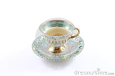 Side view of green and white teacup and saucer with tea Stock Photo