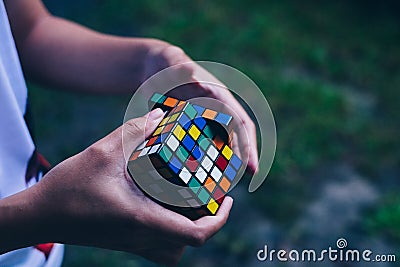 Side view of hands trying to solve the puzzle. Editorial Stock Photo
