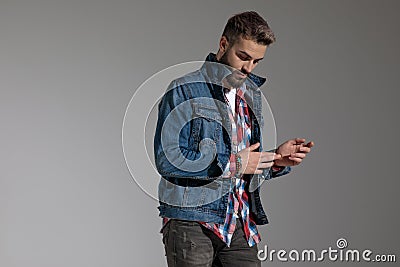 Casual guy standing and rubbing hands while looking down dramatic Stock Photo