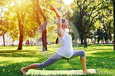 Positive pregnant woman meditating in yoga pose outdoors Stock Photo