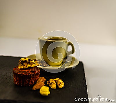 Side view on little black coffee with nut muffin, walnuts, almonds and cashew nuts, whole black stone plate, sweet energetic set Stock Photo