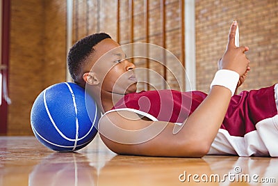 Side view of male basketball player using mobile phone Stock Photo