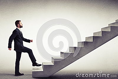 Side view of a man in a formal wear climbing concrete stairs Stock Photo