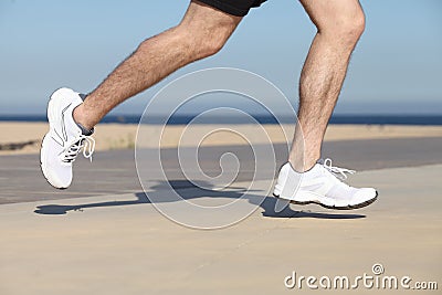 Side view of a man legs running on the concrete of a seafront Stock Photo