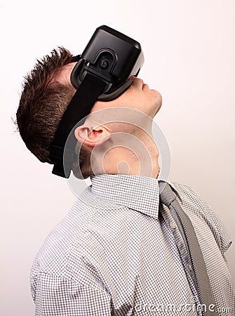 Side view of a man wearing a VR Virtual reality Oculus Rift 3D headset, exploring, looking very high upwards, wearing a shirt Editorial Stock Photo