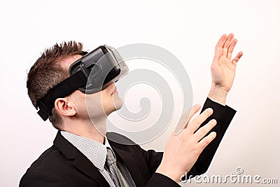 Side view of a man wearing a VR Virtual reality Oculus Rift 3D headset, touching something with his hands, exploring Editorial Stock Photo