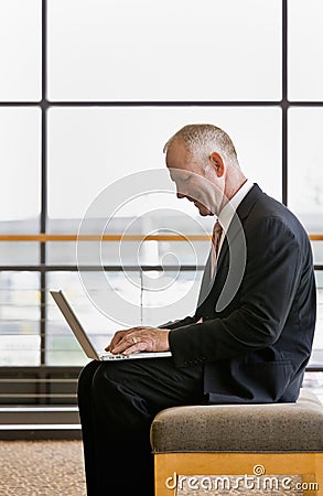 Side view of mature businessman working on laptop Stock Photo