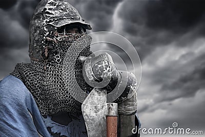 Medieval knight in chain mail holding axe. Stock Photo