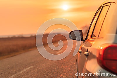 Side view mirror of car on road in autumn sunset Stock Photo