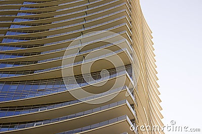 Side view of a modern corporate office building with yellow overhangs in each floor. Stock Photo