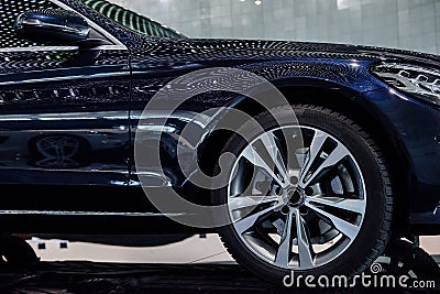 Side view of modern deep blue sport car with right led headlight, mirror, low profile tires, titanium alloy wheels and Stock Photo