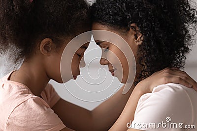 Side view mother and daughter touches foreheads moment of tenderness Stock Photo