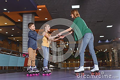 side view of mother and kids skating together Stock Photo