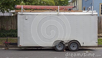 Side view of older white utility work trailer with ladders Stock Photo