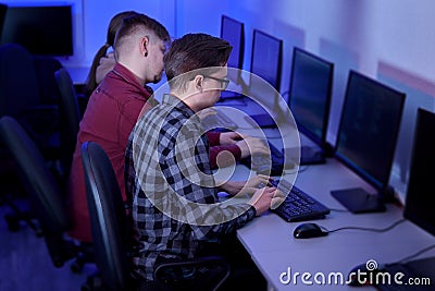 Side view of people working in the office at the computer in the evening. Stock Photo