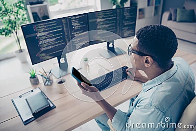 Side view photo of busy coder hacker young guy working office trying input his mobile app to smartphone workshop Stock Photo