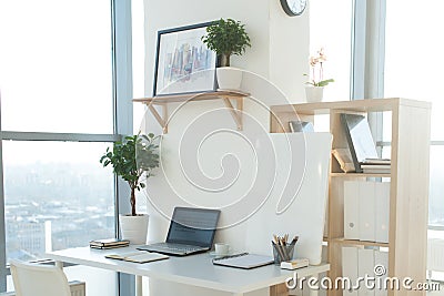 Side view picture of studio workplace with blank notebook, laptop. Designer comfortable work table, home office. Stock Photo