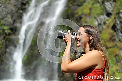 Woman taking photos with mirrorless camera in nature Stock Photo