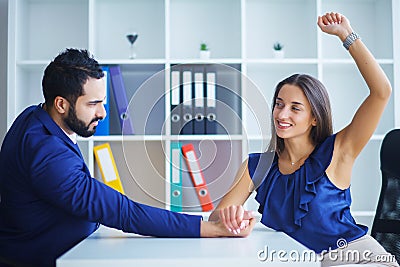 Side view portrait of man and woman armwrestling, exerting press Stock Photo