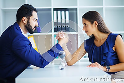 Side view portrait of man and woman armwrestling, exerting press Stock Photo