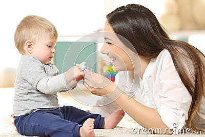 Proud mother giving a pacifier to her baby Stock Photo