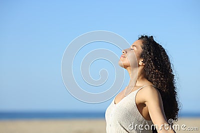 Relaxed latin girl breathing fresh air on the beach Stock Photo