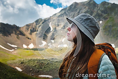 Side view portrait of a woman standing and breathing fresh air in the mountains. Profile of a female explorer breathing Stock Photo
