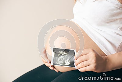 Side view of pregnant woman showing ultrasound image of baby Stock Photo