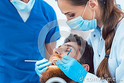 Reliable dentist using sterile instruments while cleaning teeth Stock Photo