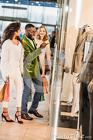 side view of smiling fashionable multiethnic people shopping together Stock Photo