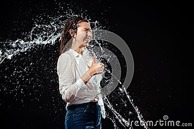 side view of smiling woman in white shirt showing thumb up while swilled with water Stock Photo