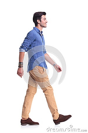 Side view of a smiling young casual man walking Stock Photo