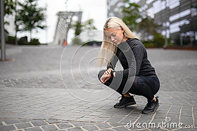 Sporty Female Runner Using Smartwatch to See Running Performance Stock Photo