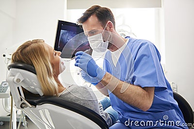 Stomatologist doing his work in dentist`s clinic Stock Photo