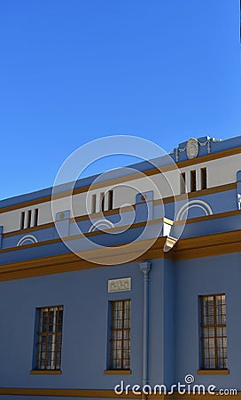 Side view of tall building with rectangular windows reflecting bright blue sky Stock Photo